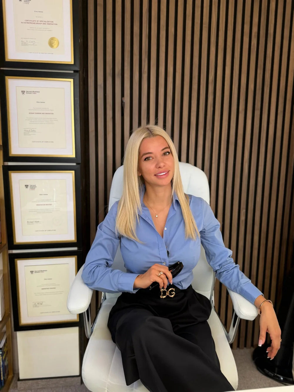 Elina Ivanova-Atanassov in her office beside her framed Harvard Business School Online certificates