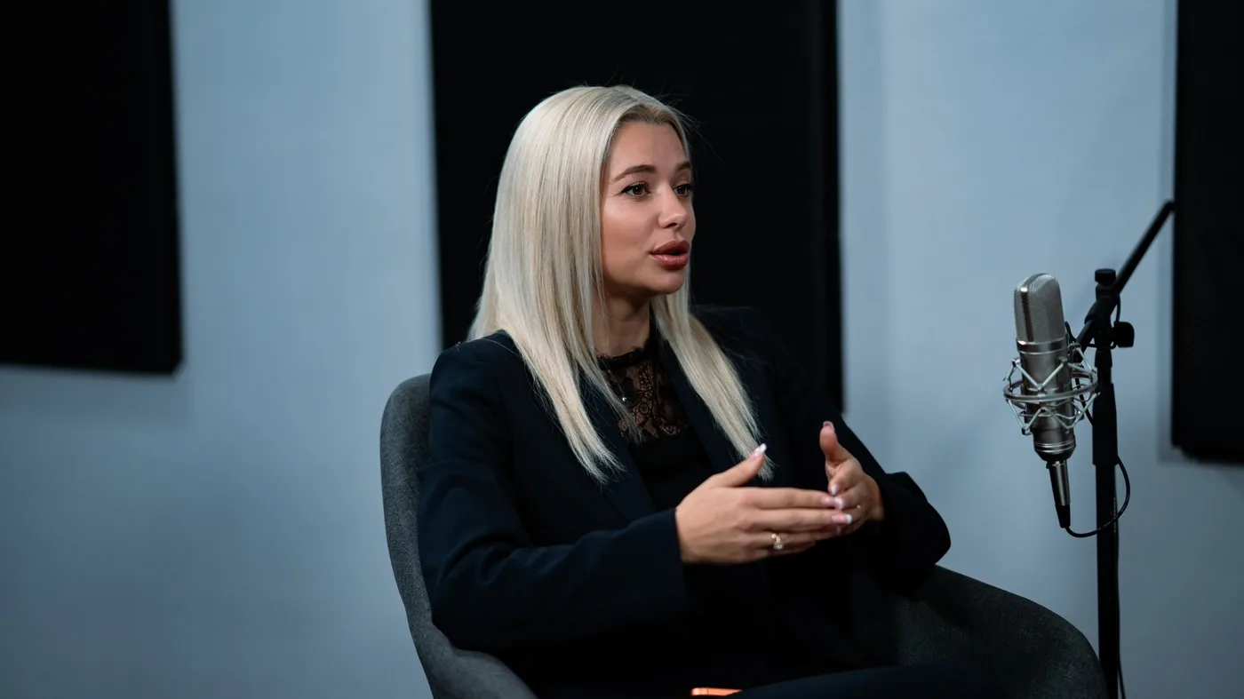 Elina Ivanova-Atanassov speaking at a podcast microphone