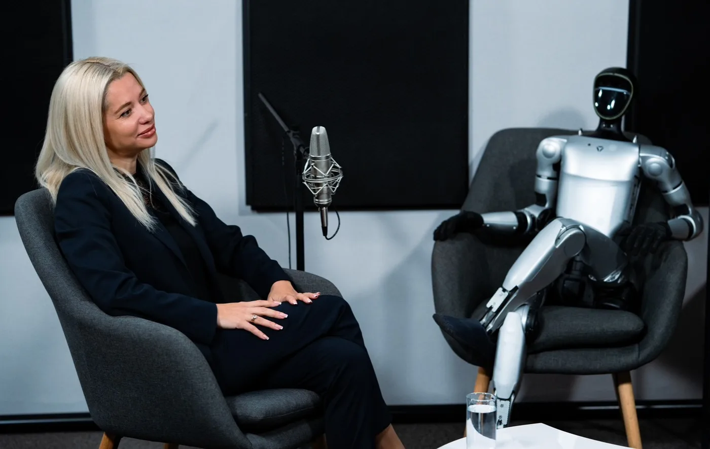 Elina Ivanova-Atanassov in a podcast studio with a humanoid robot seated beside her