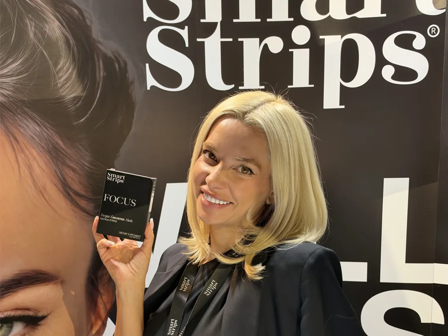 Elina Ivanova-Atanassov smiling at the Smart Strips stand with a box of FOCUS